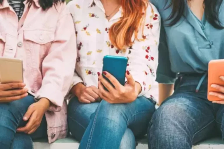 Image of teens sitting together with their cell phones.